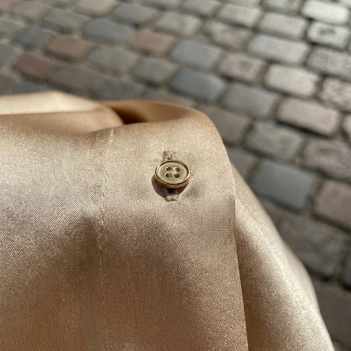 Gold elegant sleeveless blouse with buttons fabric close-up